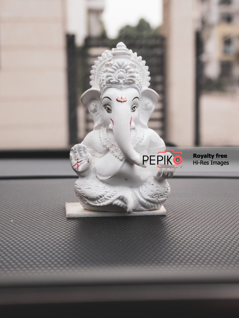 Close up of Lord Ganesh small statue in white colour