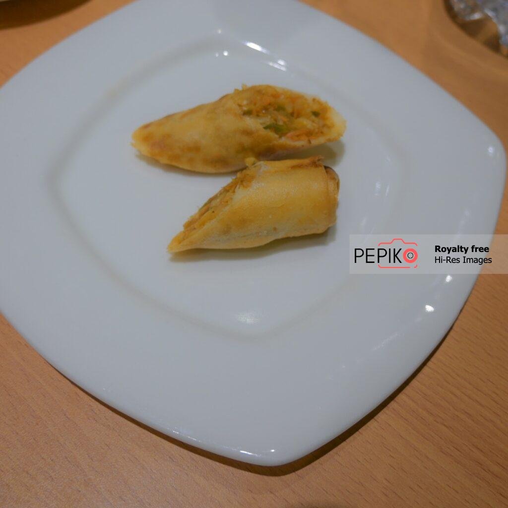 Veg Spring rolls plated on white ceramic dish plate.