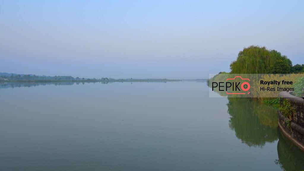 
									Vibrant view of sky and water with green trees at evening time in water dam Punjab India