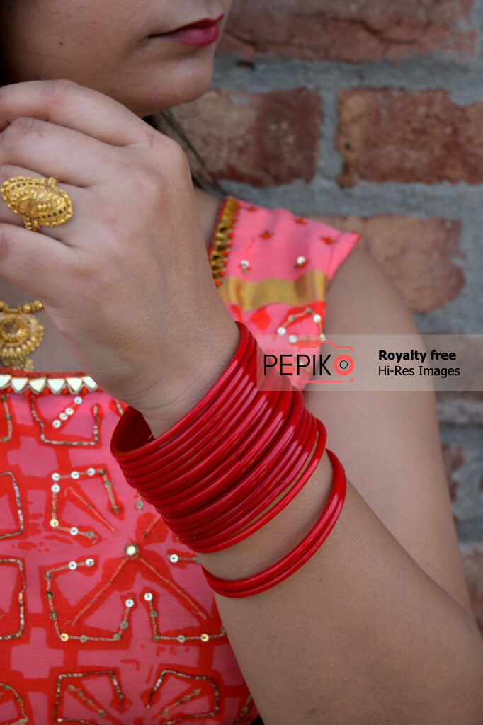 Close up of hand with vibrant red bangles