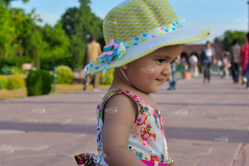 
									Adorable infant girl delighting in the Taj Mahal, Agra, dressed in a charming floral outfit