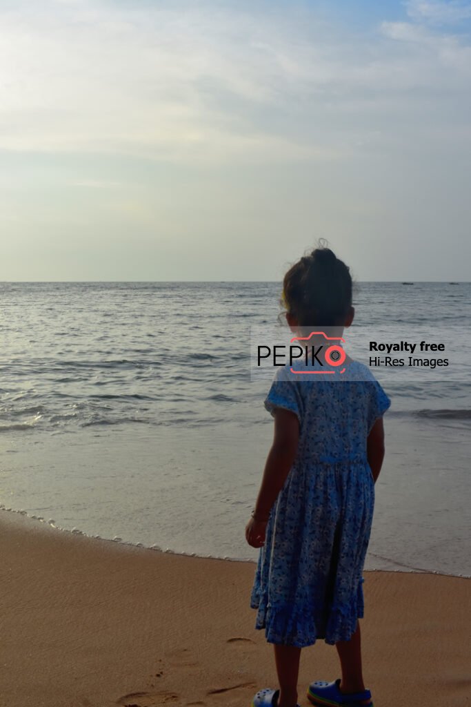 
									Beautiful photos of young child traveler in GOA in India enjoying at water sand beach