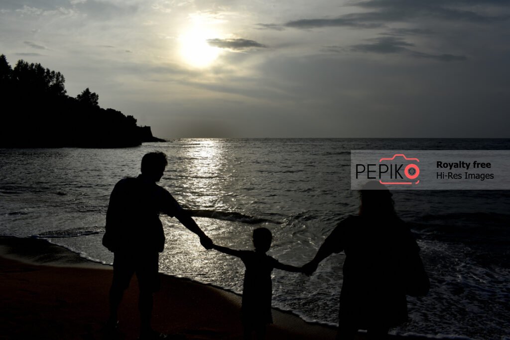 Sunset view with Young couple with their kid traveling in GOA India and enjoying at beach