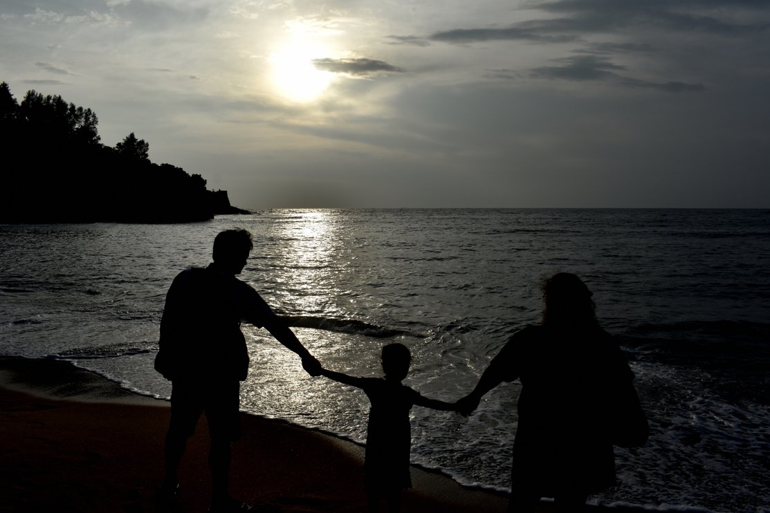 Sunset view with Young couple with their kid traveling in GOA India and enjoying at beach