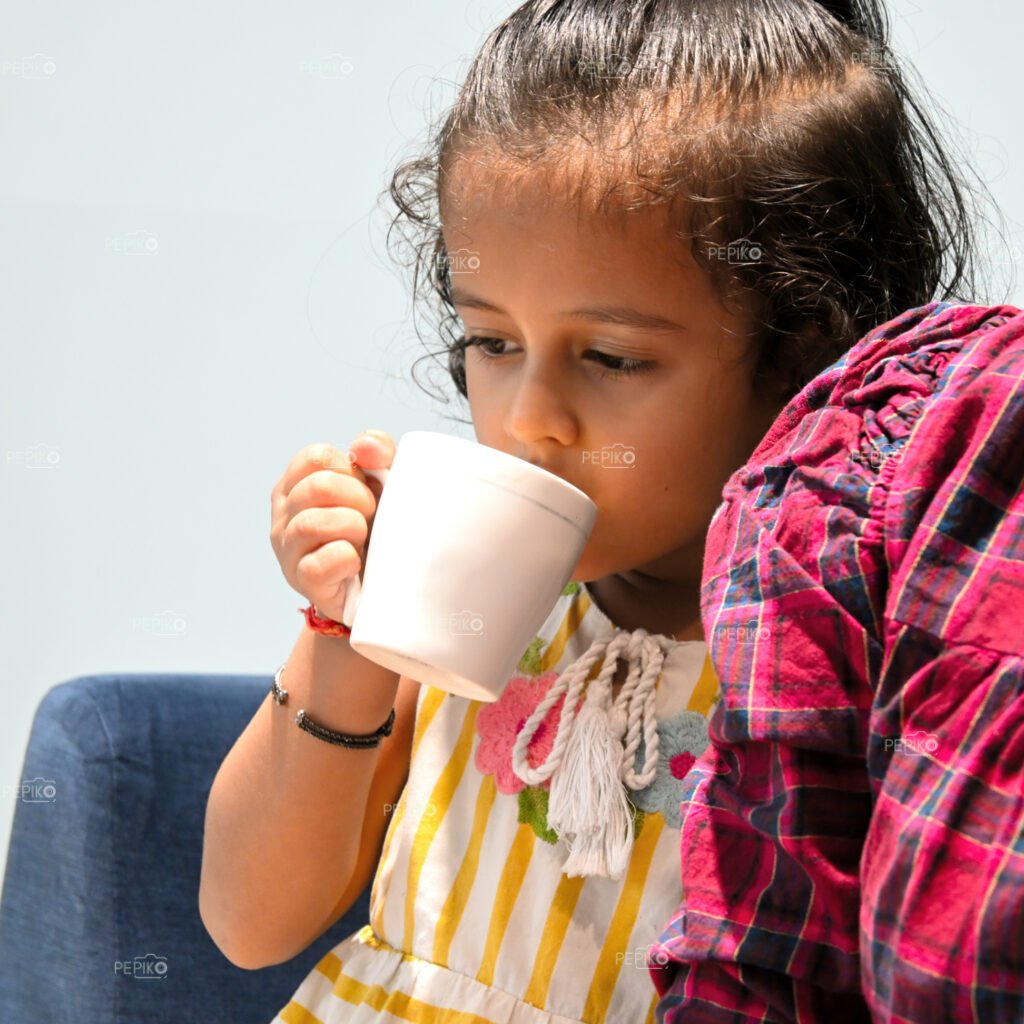 Picture of child girl enjoying cup of tea / coffee