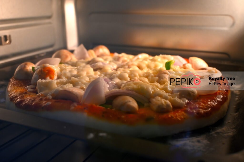 
									Delicious mushroom and sweet corn pizza being baked / cooked in microwave oven