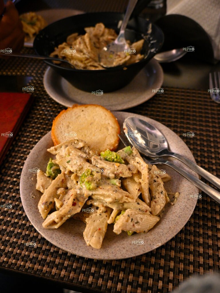 
									Picture of tempting Italian white sauce pasta served with garlic bread