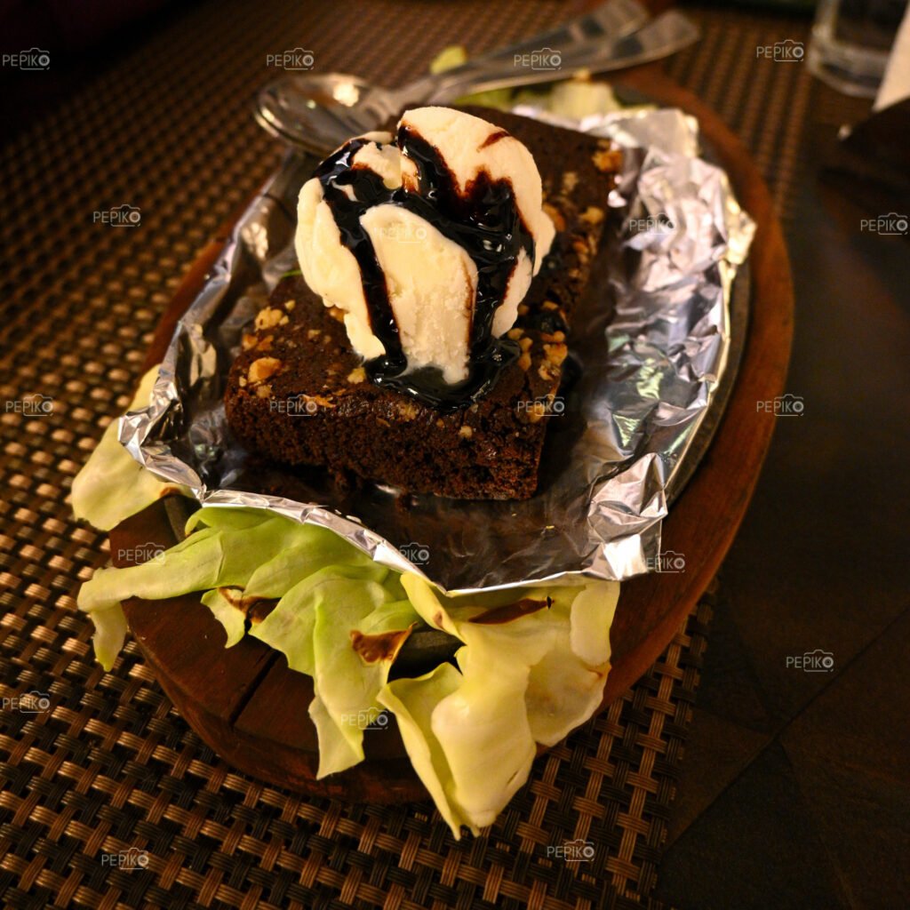 
									Sizzling walnuts brownie with vanilla ice cream served with hot liquid chocolate over it