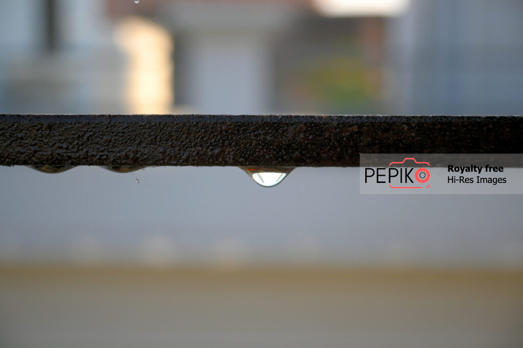 Macro photo of water drop on iron grill during rain