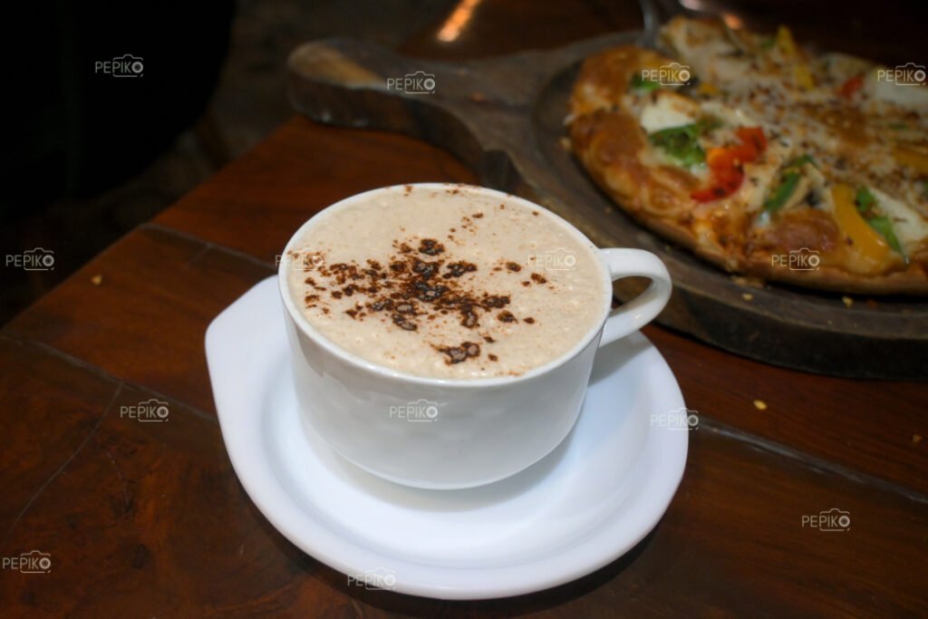 Cup of hot coffee with vegetable pizza on wooden table