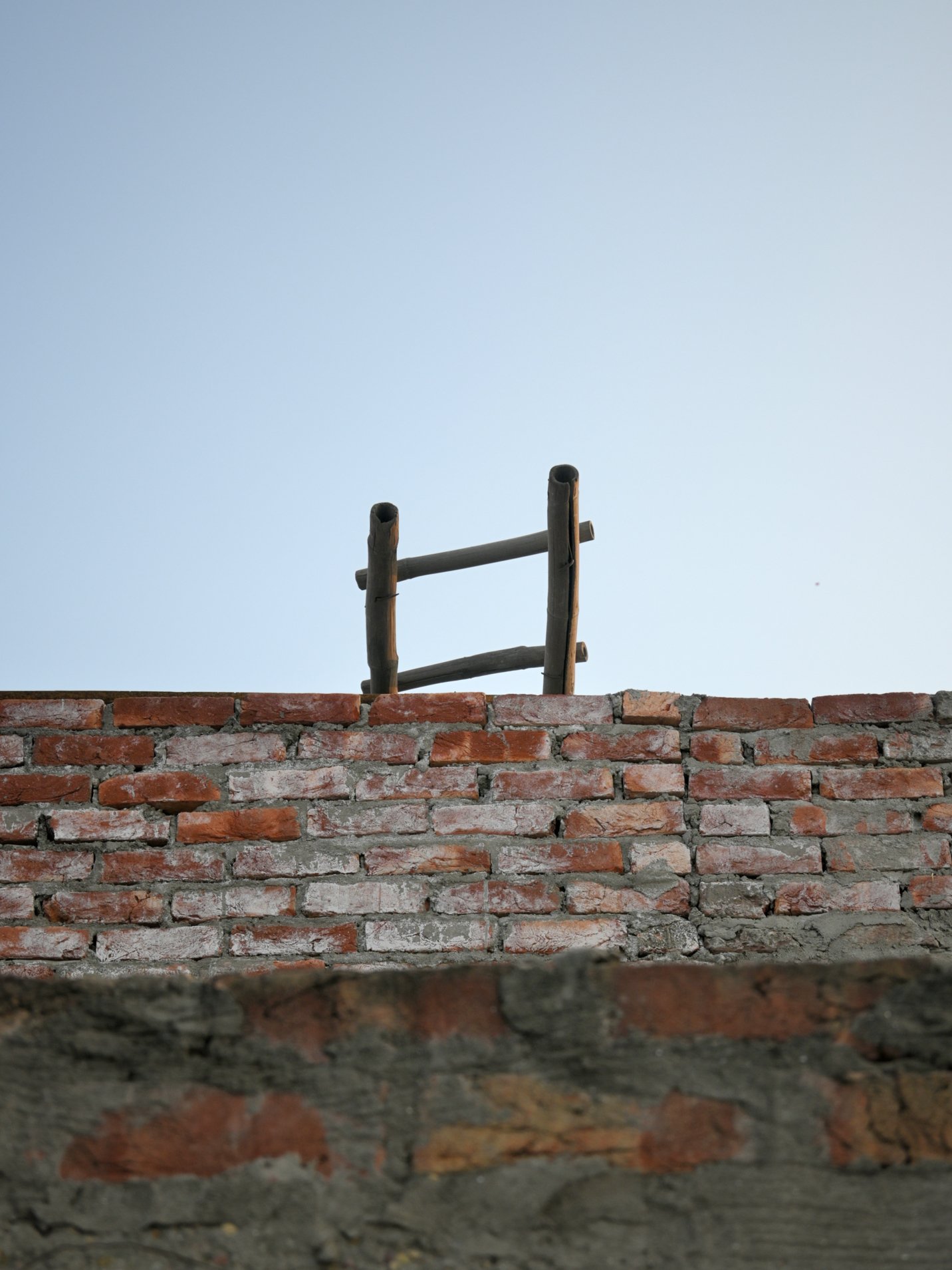 Picture of wooden ledder with red brick wall