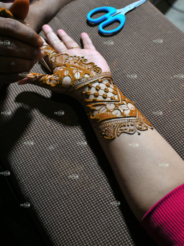 Picture of women hand applying Heena / mehndi art