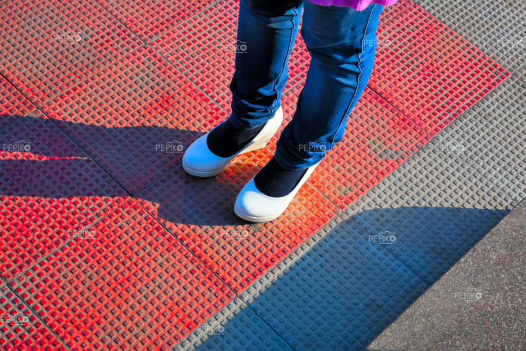 Close up of street with women white heels